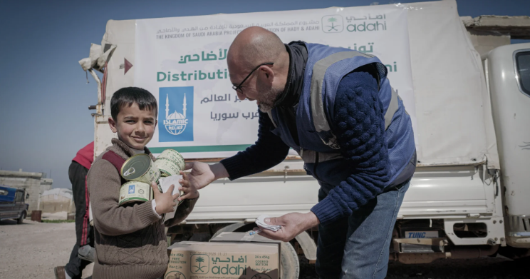 An IRFS Global volunteer handing an emergency aid parcel to a child
