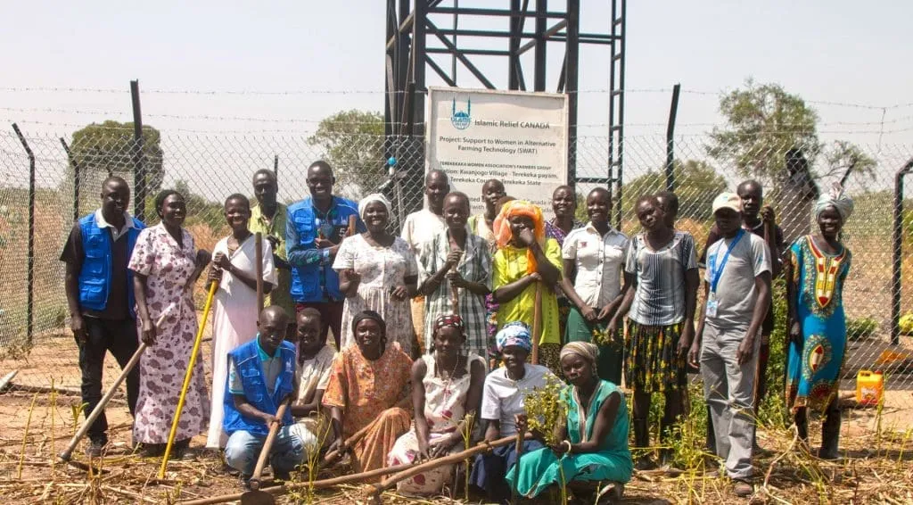 A community collecting clean water from a water point built by IRFS Global